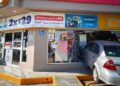 Automóvil gris Chevrolet Aveo incrustado en la fachada de una tienda de conveniencia