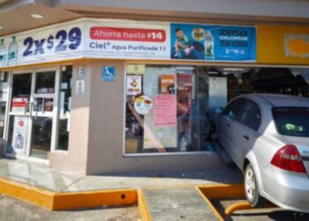 Vehículo Chevrolet Aveo dañado tras impacto en tienda de conveniencia.