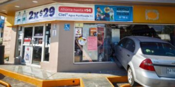 Vehículo Chevrolet Aveo dañado tras impacto en tienda de conveniencia.